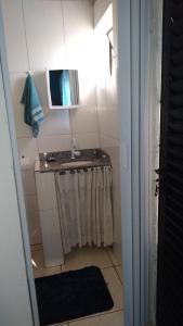 a bathroom with a sink and a mirror at Hostel do Enzo in Itanhaém