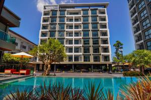 Ban Si ThanThe S Block Condotel的一栋建筑前有一座游泳池