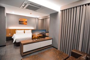 a hotel room with a bed and a television on a table at The S Block Condotel in Ban Si Than