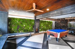 a pool table in a room with a green wall at The S Block Condotel in Ban Si Than