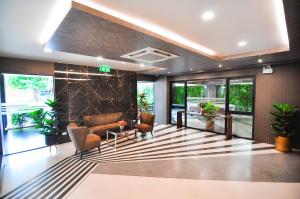 a lobby with a couch and chairs and windows at The S Block Condotel in Ban Si Than