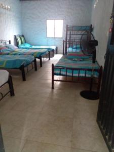 a room with four beds in a room with a window at Posada la tranquilidad in Villavieja