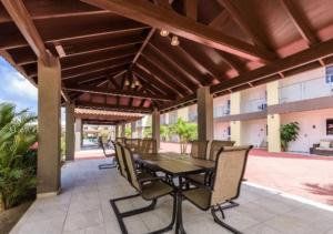 un patio extérieur avec une table et des chaises dans l'établissement Apartamento Vacacional en Aruba Cerca a la Playa, à Palm-Eagle Beach