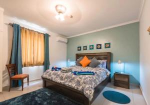 une chambre avec un grand lit et une chaise dans l'établissement Apartamento Vacacional en Aruba Cerca a la Playa, à Palm-Eagle Beach