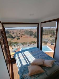 Un dormitorio con una cama y una ventana grande. en Casa COSMOS golf., en Algarrobo