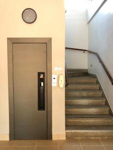 um elevador com um relógio na parede e escadas em Caiçara Hotel em Santos