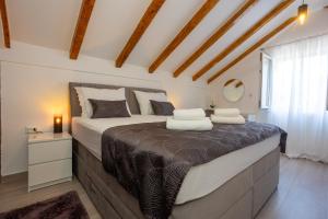 a bedroom with a large bed with two pillows on it at Stone House Iris in Split