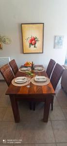 a wooden table with plates and wine glasses on it at Family Home Myrina Lemnos in Myrina