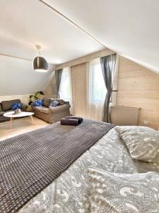 a bedroom with a large bed and a living room at Karczma Kubalonka in Istebna +104 photos
