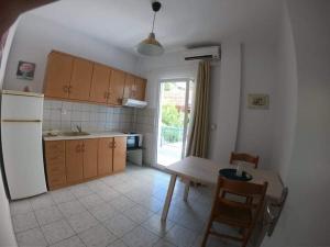 a kitchen with a table and a refrigerator at MAGDALINOS APARTMENTS (3) in Nea Skioni