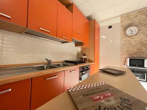 una cucina con armadi arancioni e piano di lavoro di Casa Borgomonte a Otranto