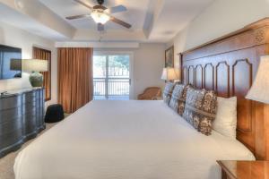 a bedroom with a large bed with a wooden headboard at RiverStone Condo Resort & Spa in Pigeon Forge