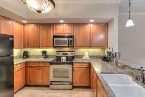 a kitchen with wooden cabinets and stainless steel appliances at RiverStone Condo Resort & Spa in Pigeon Forge