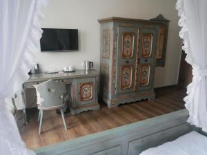 1 dormitorio con escritorio, armario y silla en Hotel BurgGartenpalais, en Rothenburg ob der Tauber