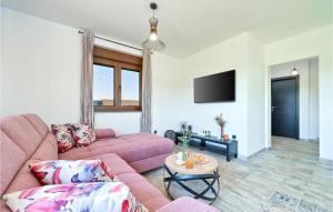 a living room with a pink couch and a tv at Stunning Home In Pitomaca With Wifi in Pitomača