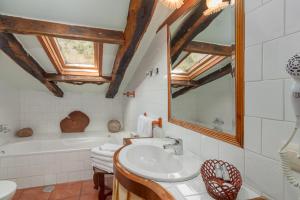 een badkamer met een wastafel en een bad bij Casona De La Salceda in Treceño