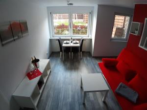 een woonkamer met een rode bank en een tafel bij Ferienwohnung im schönen Zellertal in Wachenheim