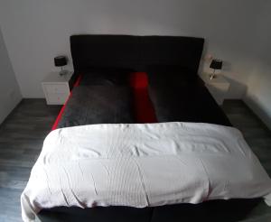 a black and white bed with a red tie on it at Ferienwohnung im schönen Zellertal in Wachenheim