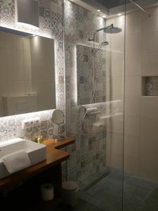 a bathroom with a shower with a sink and a mirror at Hotel BurgGartenpalais in Rothenburg ob der Tauber