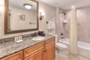 a bathroom with a sink and a toilet and a mirror at RiverStone Condo Resort & Spa in Pigeon Forge