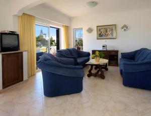 uma sala de estar com duas cadeiras azuis e uma televisão em 614 Villa Atlantico em Alagoas