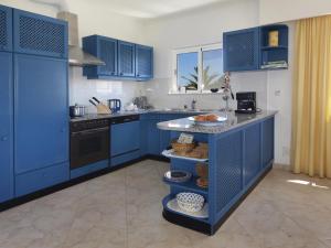 uma cozinha azul com armários azuis e um balcão em 614 Villa Atlantico em Alagoas
