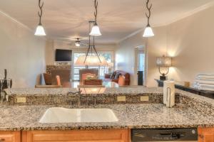 a kitchen with a sink and a living room at RiverStone Condo Resort & Spa in Pigeon Forge