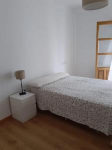 een slaapkamer met een bed en een lamp op een nachtkastje bij Antequera apartamento céntrico in Antequera