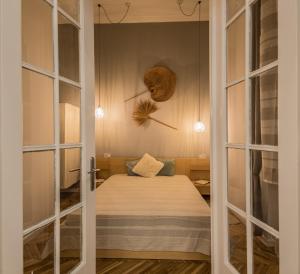 a small room with a bed and large windows at SemmiHome Budapest Semmelweis Street in Budapest