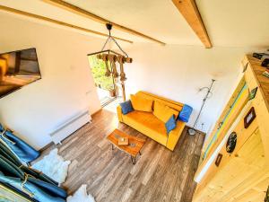 uma sala de estar com um sofá amarelo e uma mesa em Tiny House Retreat Bran em Bran