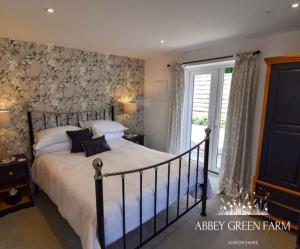 a bedroom with a large bed and a window at Abbey Green Farm in Wem