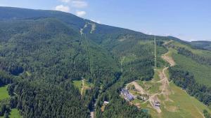 an aerial view of a mountain with trees and a road at Apartamenty Pilsko Korbielów komfortowe mieszkania dla rodzin i narciarzy w Beskidach in Korbielów