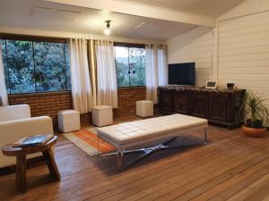 ein Wohnzimmer mit einem Sofa und einem TV in der Unterkunft Casa 4 dorms 2 suites - localização perfeita no centrinho e rodeada de natureza in Alto Paraíso de Goiás