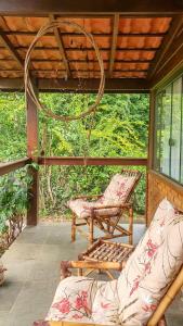 a screened in porch with two chairs and a couch at Casa 4 dorms 2 suites - localização perfeita no centrinho e rodeada de natureza in Alto Paraíso de Goiás