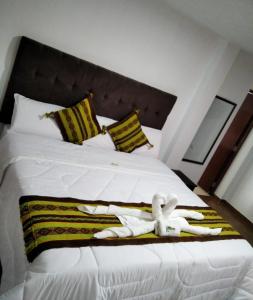 a white bed with two white towels on it at Hotel Ñuñurco Travellers in Chachapoyas