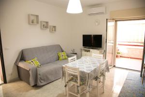 un soggiorno con divano, tavolo e TV di Sweet House Taormina a Taormina