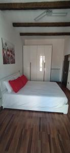 una camera con un letto bianco e un cuscino rosso di Casa di Nonno a Isernia