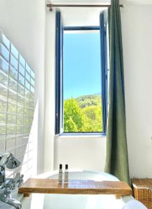 uma casa de banho com uma banheira e uma janela em U Fiordalisu em Bastelica