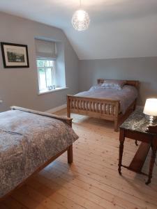 a bedroom with two beds and a table with a lamp at Drumlaghy House in Florencecourt