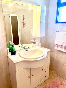 ein Badezimmer mit Waschbecken und Spiegel in der Unterkunft Casa Neves three bedrooms and fantastic sea view in Arco da Calheta