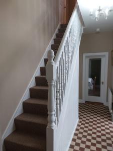 a hallway with stairs with a checkered floor at Drumlaghy House in Florencecourt