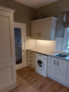 a kitchen with a washing machine and a sink at Drumlaghy House in Florencecourt