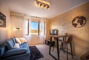 uma sala de estar com um sofá azul e uma mesa em Rivereto em Rijeka