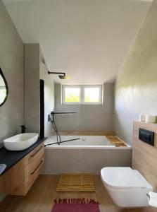 a bathroom with a tub and a toilet and a sink at Apartamenty Osmolice w Stawach in Dęblin