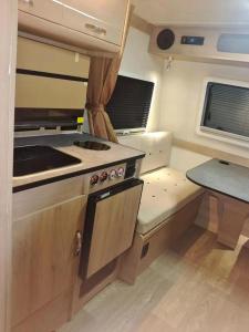 Muscat Caravans في بركاء: مطبخ صغير مع موقد وطاولة