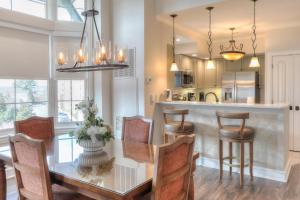 a kitchen and dining room with a glass table and chairs at RiverStone Condo Resort & Spa in Pigeon Forge