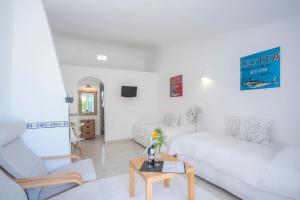 a white living room with a white couch and a table at Algarve breeze studio in a subtropical garden in Luz