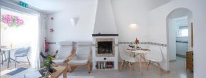 a living room with a fireplace and a table and chairs at Algarve breeze studio in a subtropical garden in Luz