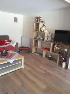 JENNY'S HOME في Pleurtuit: غرفة معيشة مع تلفزيون وأرضية خشبية