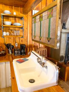 ein weißes Waschbecken in einer Küche mit einer Theke in der Unterkunft La Sapinette in Val-David